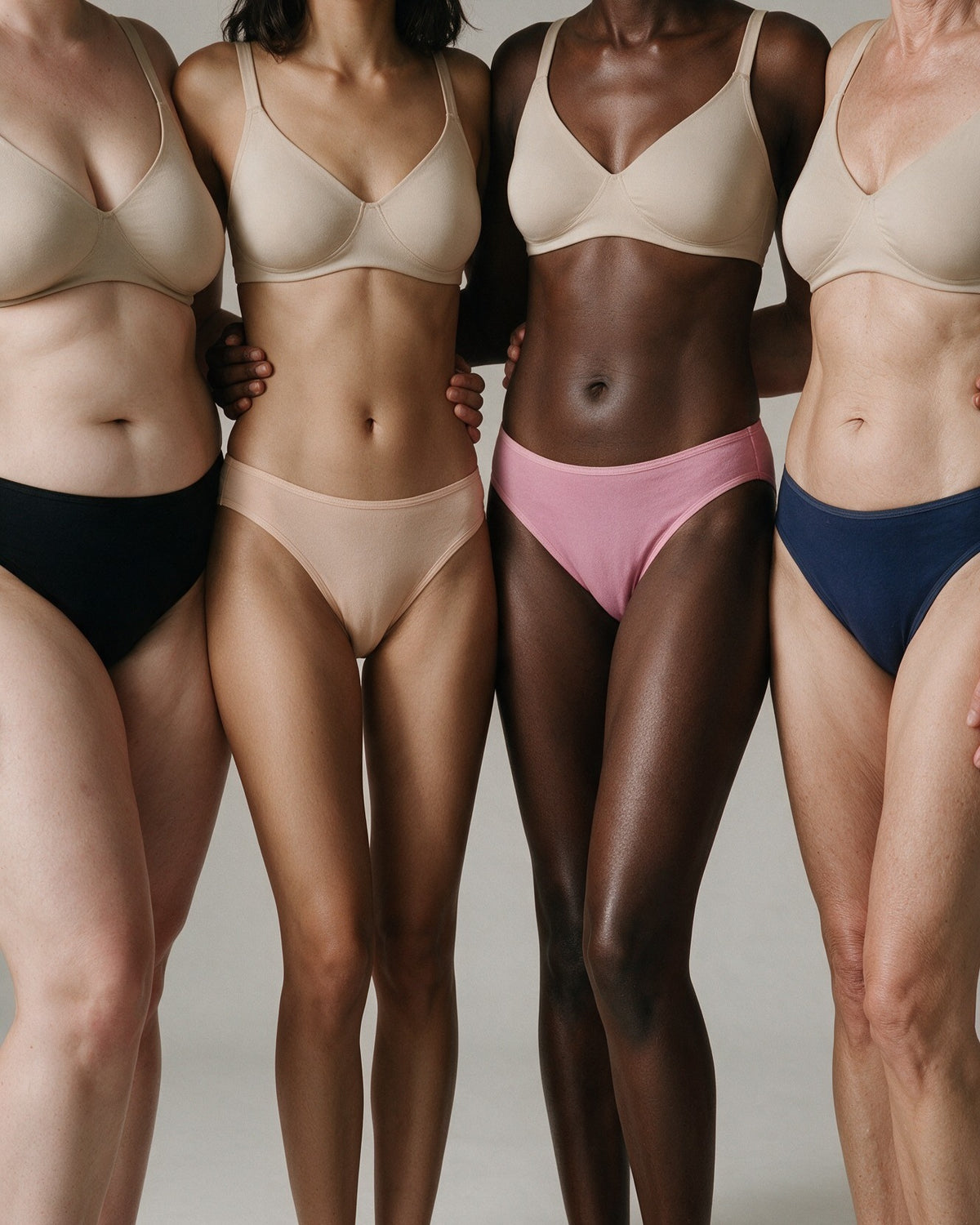 Four women wearing Elodie bamboo bikini briefs in Black, Beige, Pink and Navy