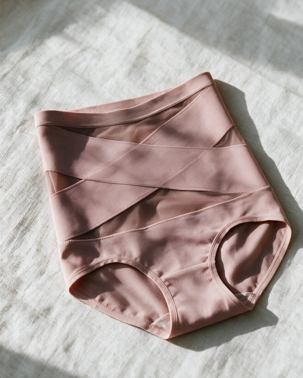 Haven Postpartum Support Brief in Dusty Rose, laid on linen