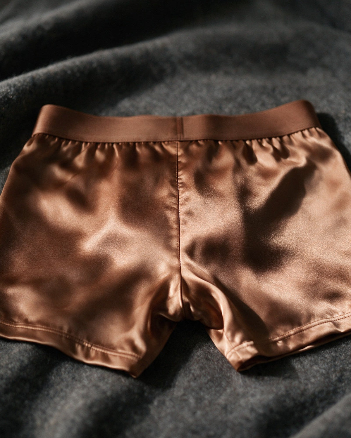 Mayfair men's silk-blend boxer in Bronze, back view of the satin in low light