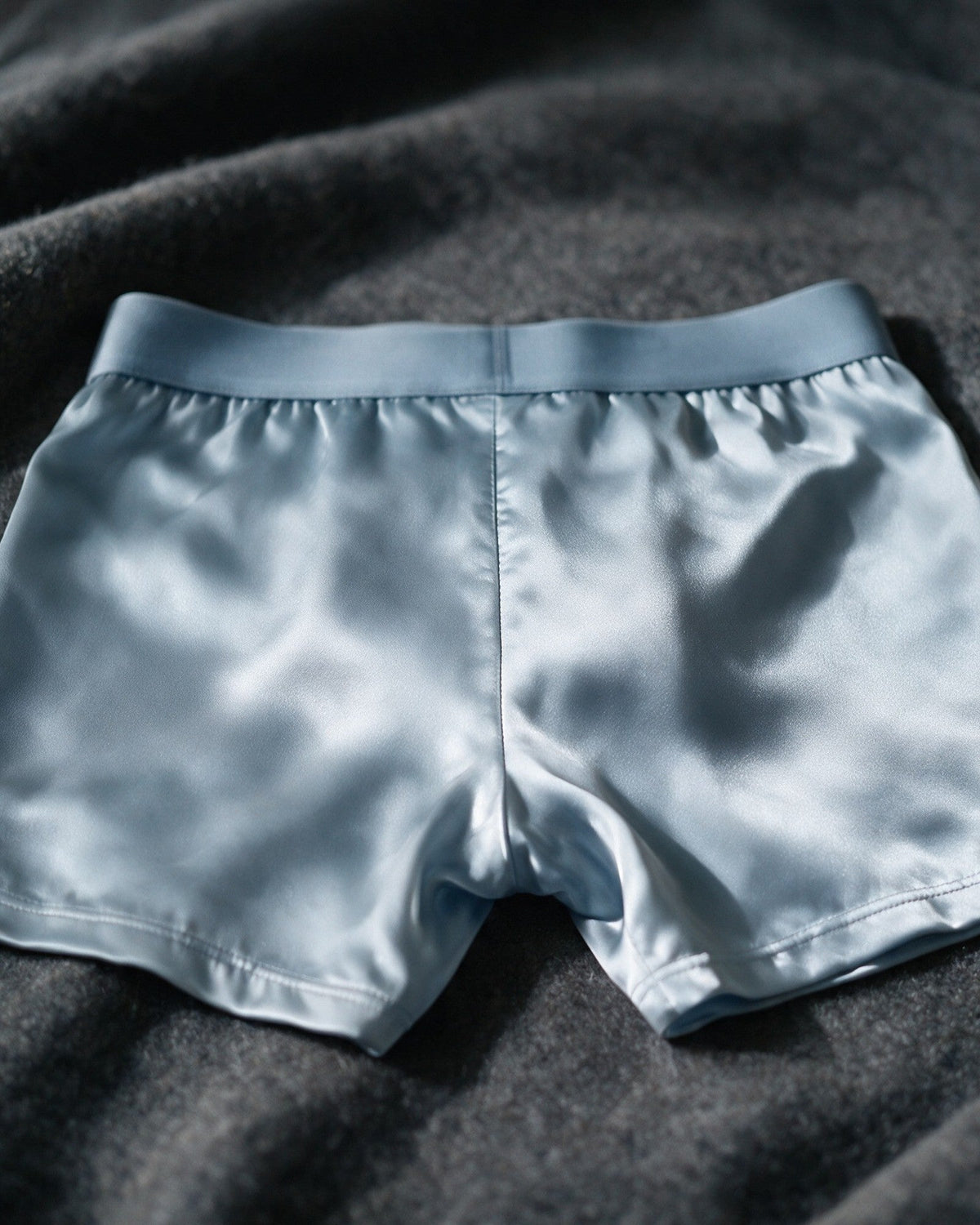 Mayfair men's silk-blend boxer in Light Blue, back view of the satin in low light